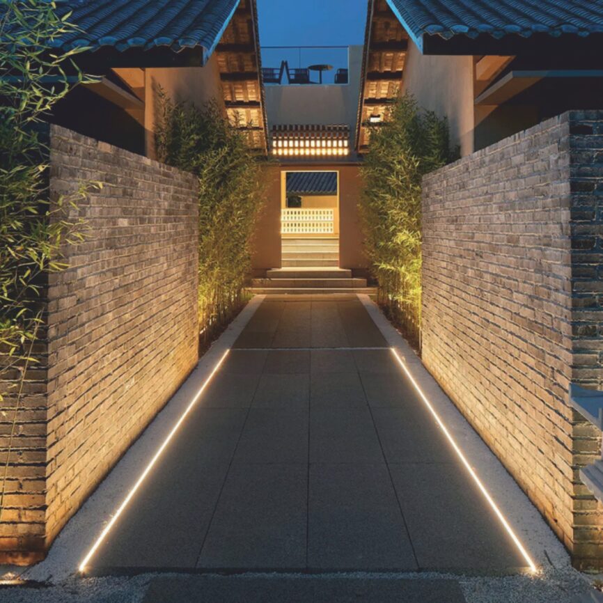 EST-SFL04AL2-1000 LED inground linear light illuminating a garden pathway.